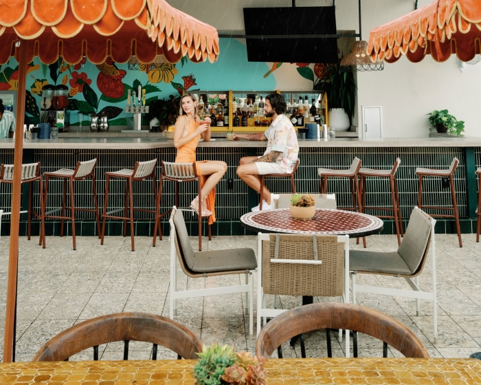 two people sitting at an out door bar
