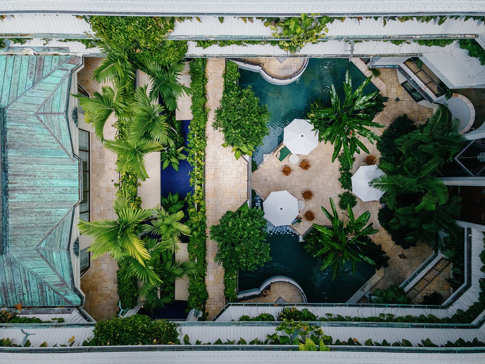 Aerial view of a pool area with palm trees and lounge chairs