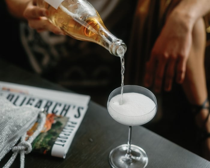 someone pouring a drink into a glass