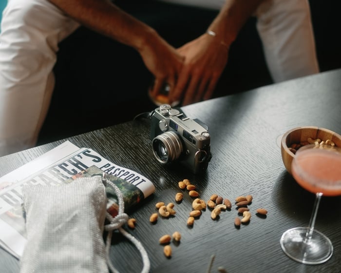 table with a camera and a bowl of nuts