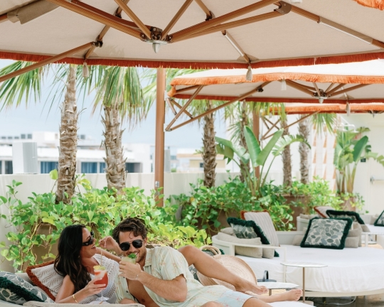 A couple enjoy poolside beverages at Mayfair House Hotel & Garden